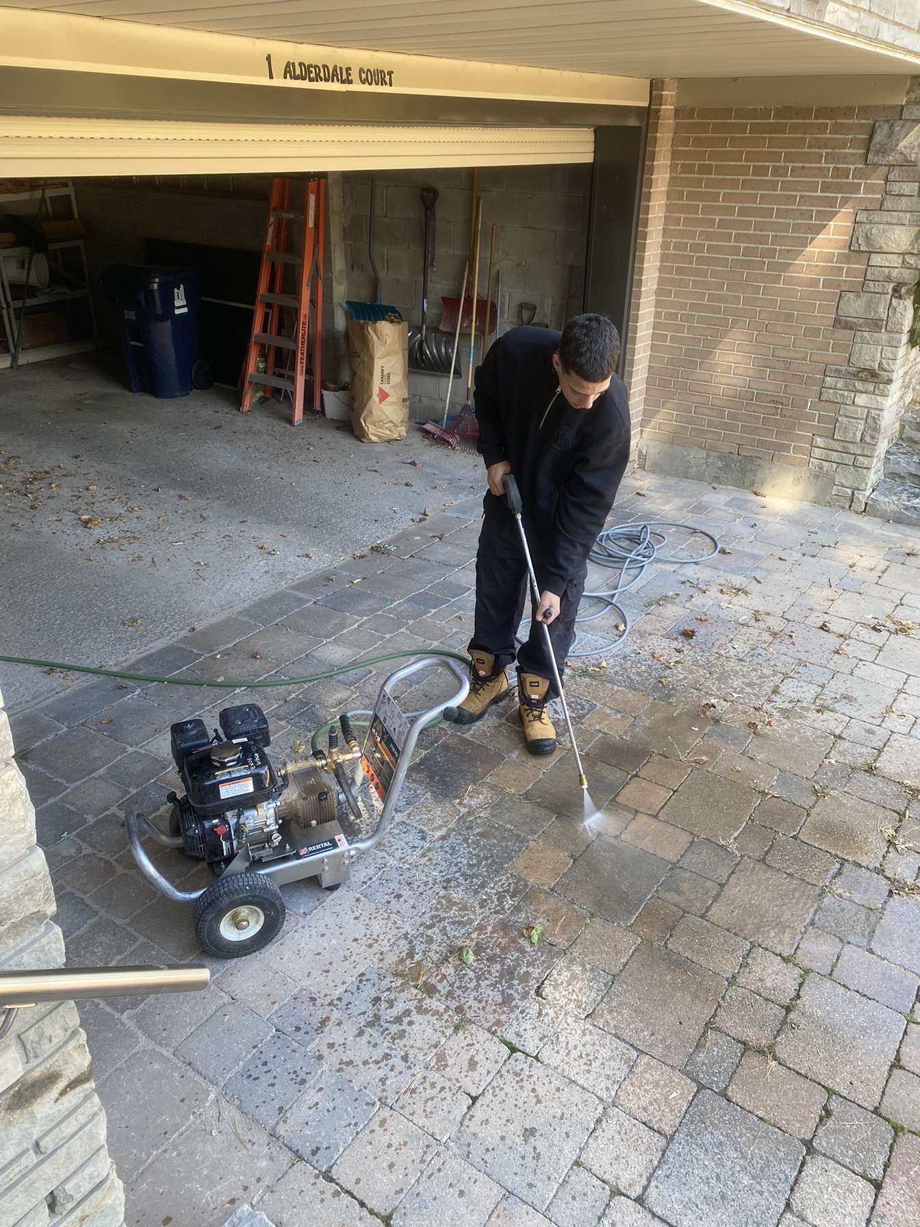 Thirlwell technician pressure washing an interlock driveway at a Toronto home