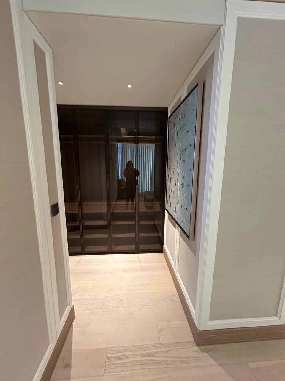 Passage with mirror paneling, vintage sconces, and mood-lit transitions.