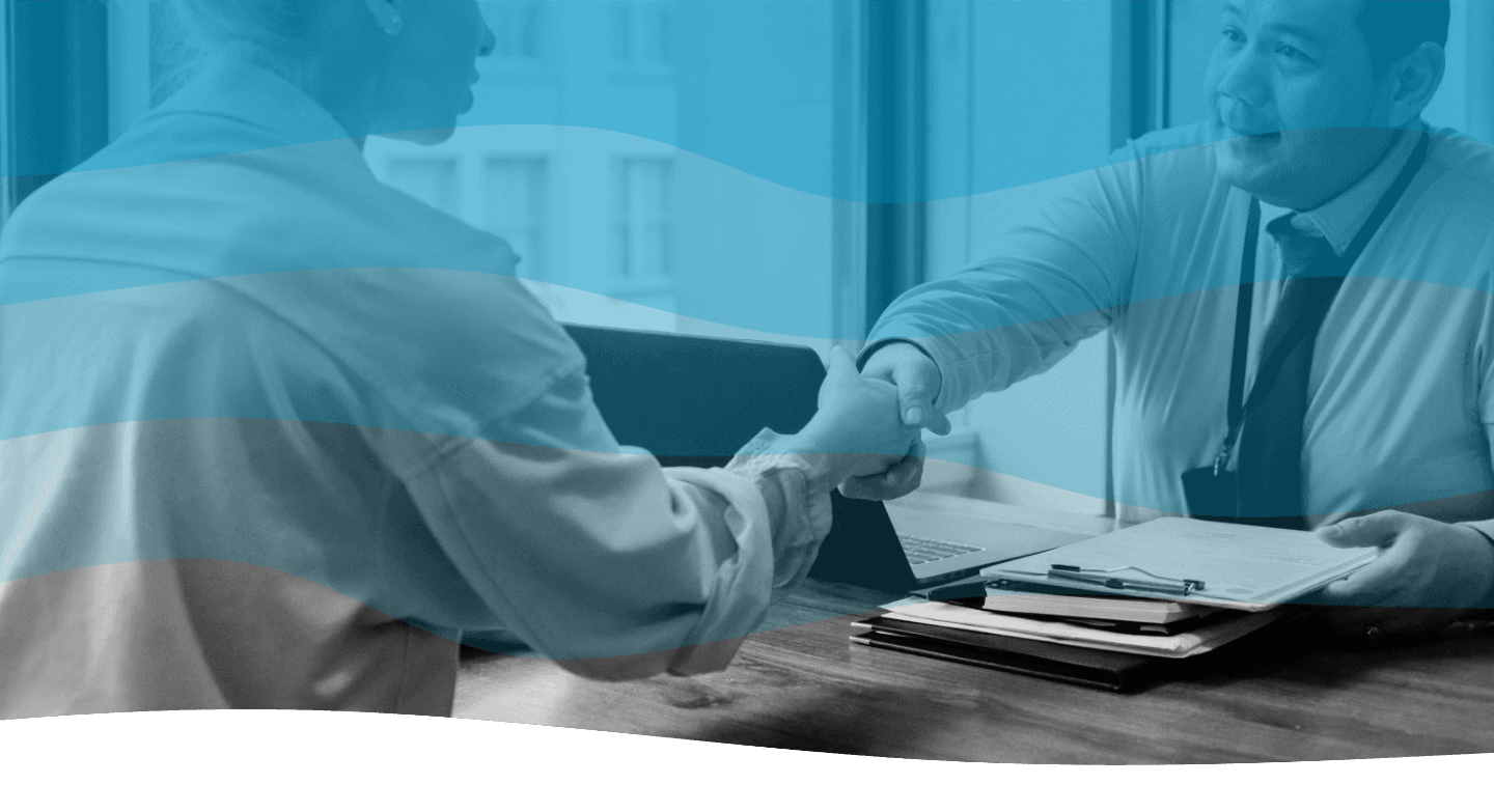 Four individuals are engaged in a lively conversation, smiling warmly at one another, against a backdrop featuring a blue and white striped design.