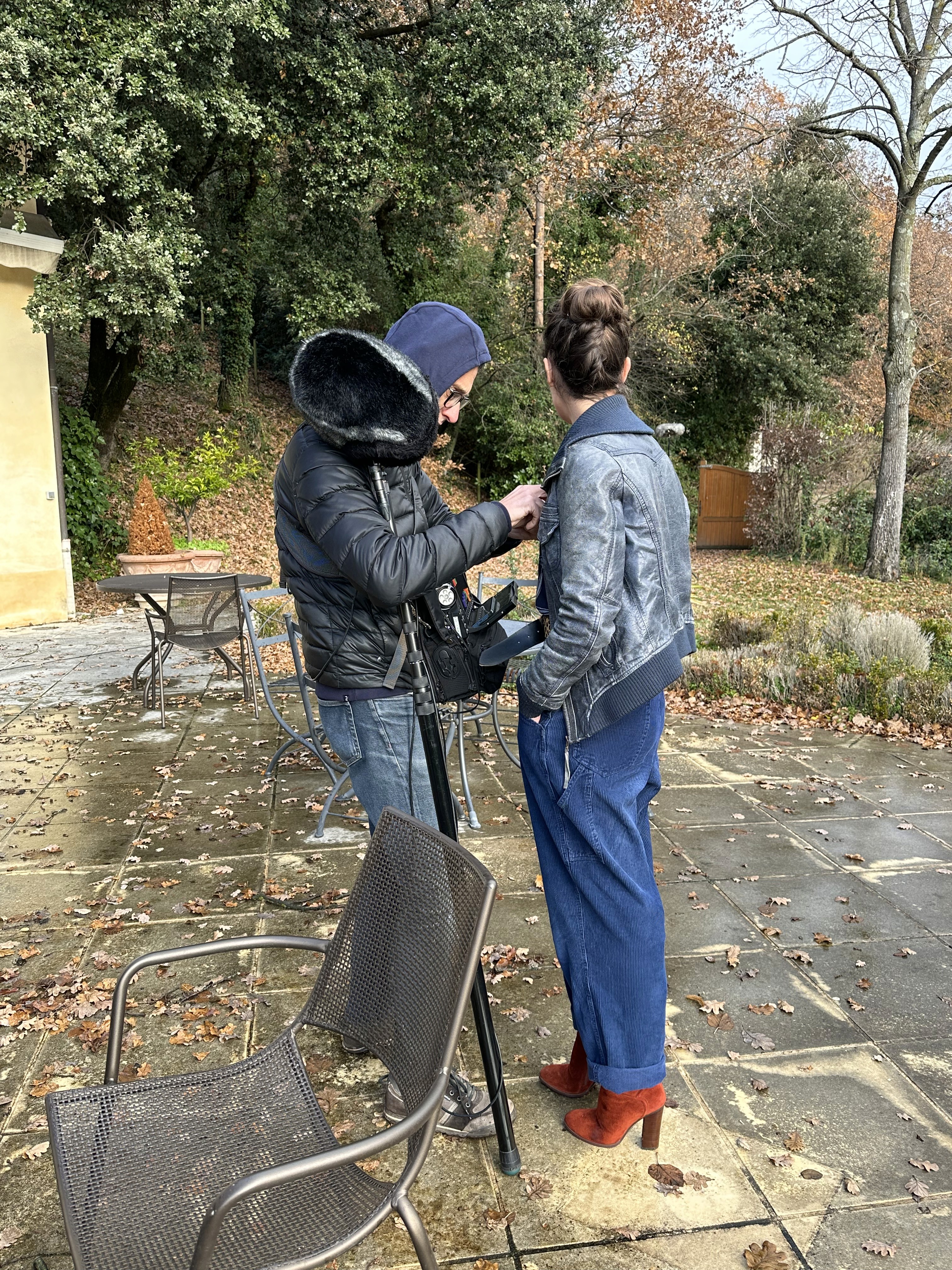 Woman in pink leather jacket crouching outdoors at night