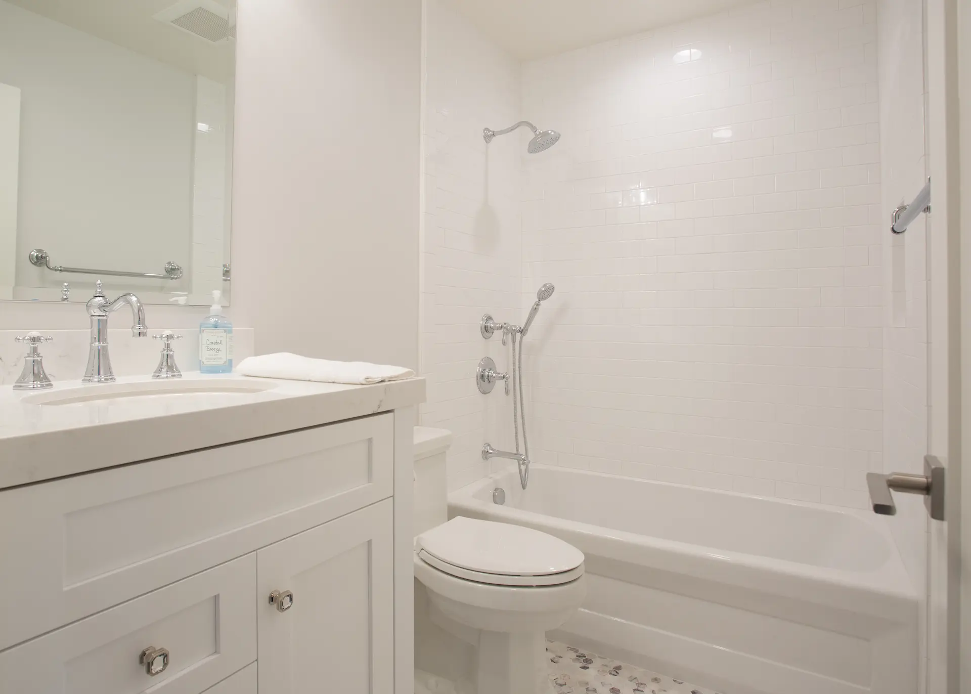 Close-up of elegant secondary bathroom with muted tones, custom vanity and alcove tube with shower. From Dana Point Cape Cod remodel, photo by Chris Darnall.