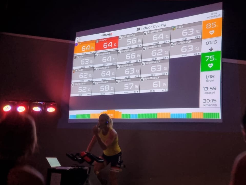La salle d'indoor cycling d'Officina25, avec l'écran Uptivo qui affiche les fréquences cardiaques du groupe