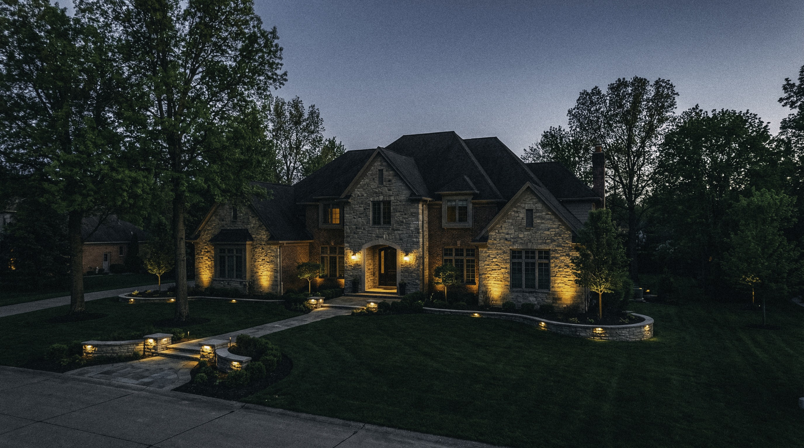 Modern living room with abstract art, beige sectional sofa, indoor plants, and large windows.