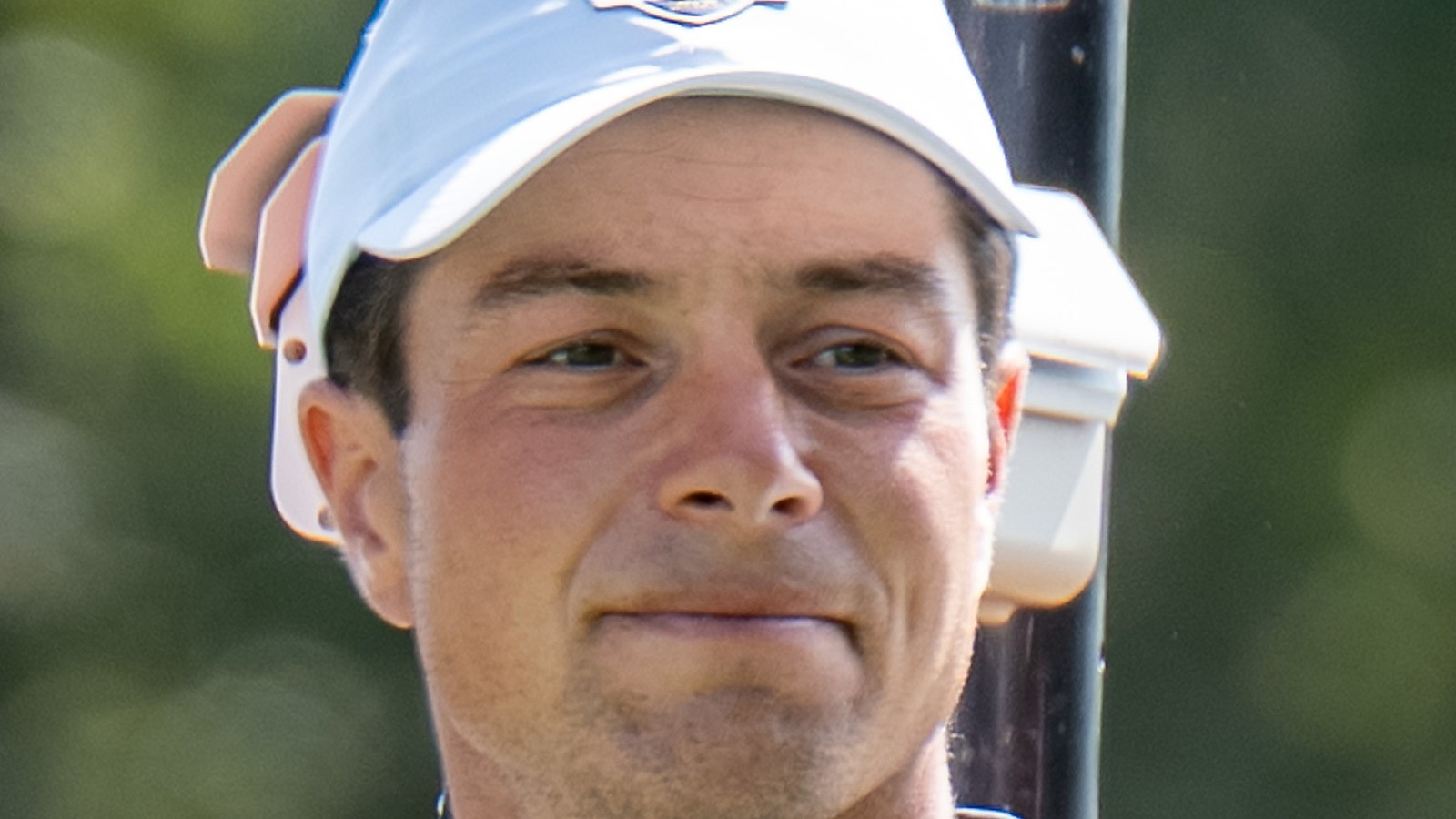 Close-up of Viktor Hovland in a white Ryder Cup cap, face centered