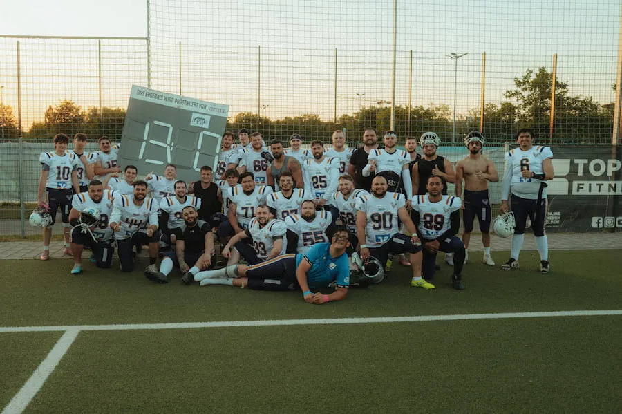 Gruppenfoto des gesamten Teams der Balingen Bucks in weißen Trikots auf dem Spielfeld.