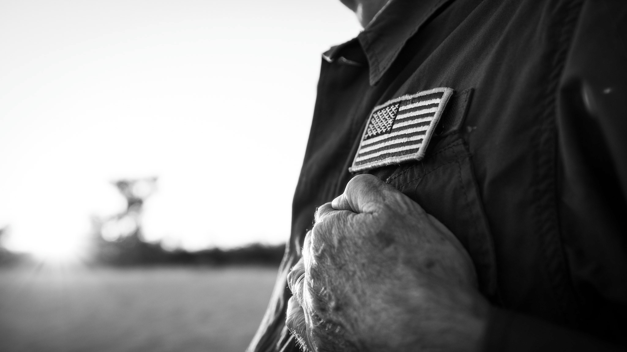 Man with hand over heart near American flag patch