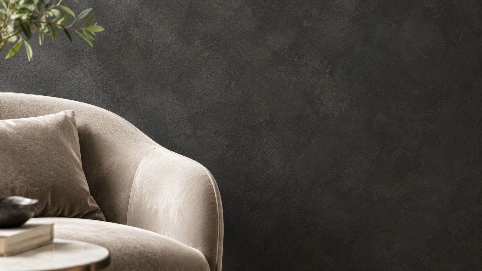 A luxurious beige velvet armchair positioned against a dark, textured charcoal wall in a modern living room.