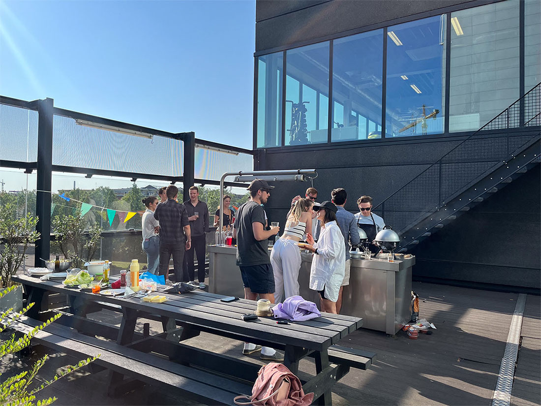 People gathered on a rooftop around an outdoor table