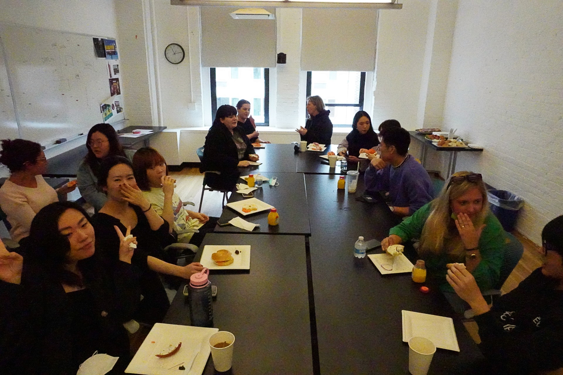 A photo of a group of people, talking to each other while sitting at a conference table in an office room.