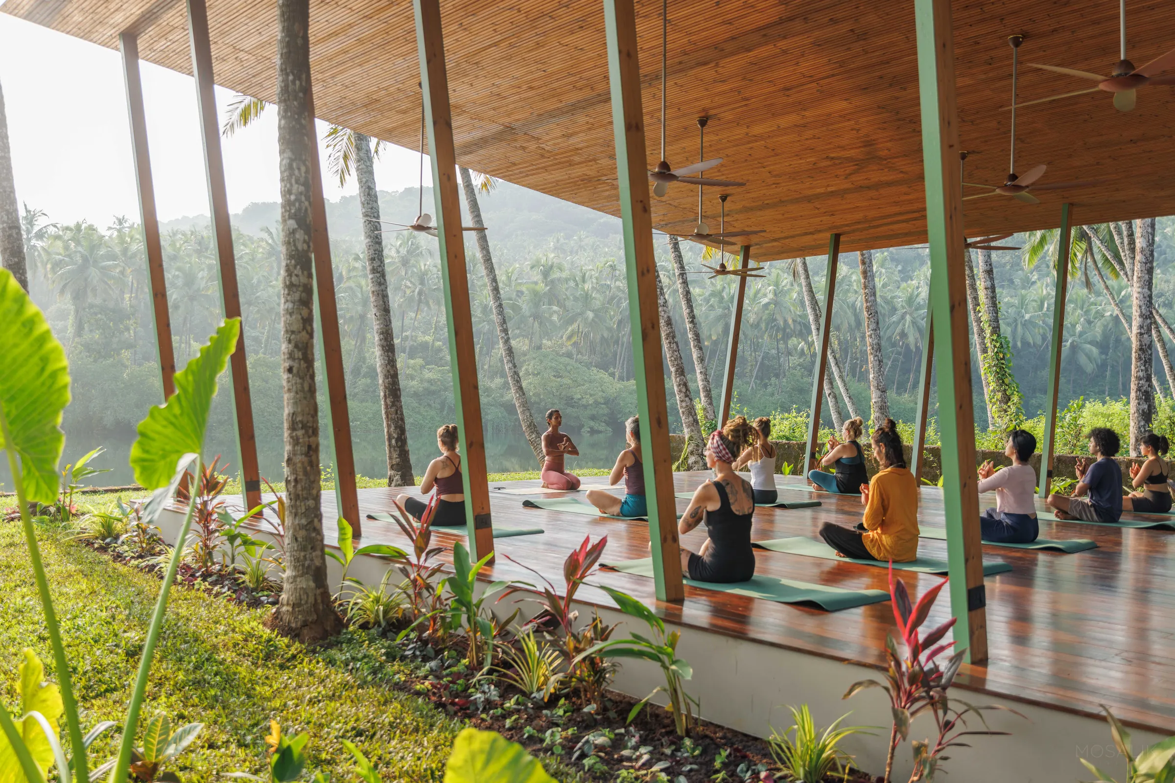 Yoga class in the open-air pavilion, seen from the tropical garden