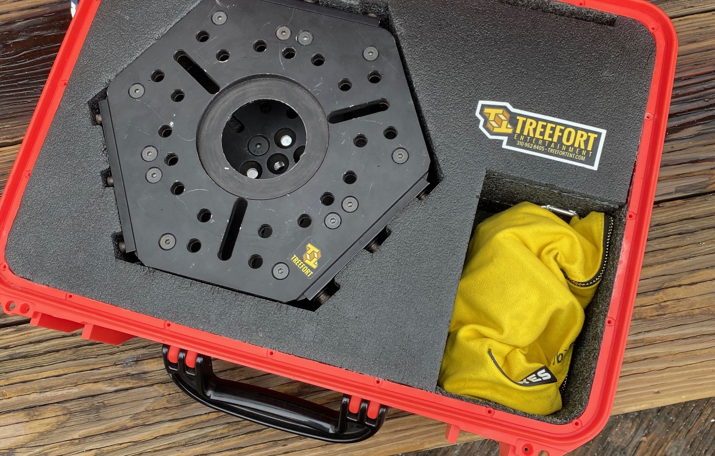 Treefort Entertainment pelican case open on the Santa Monica Pier boardwalk showing a black hexagonal vibration-isolator mounting plate in custom foam