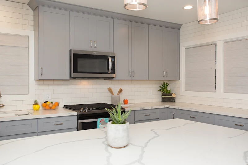 Rustic farmhouse kitchen shaker style blue/grey cabinetry with quartz countertops. Photo by Chris Darnall.
