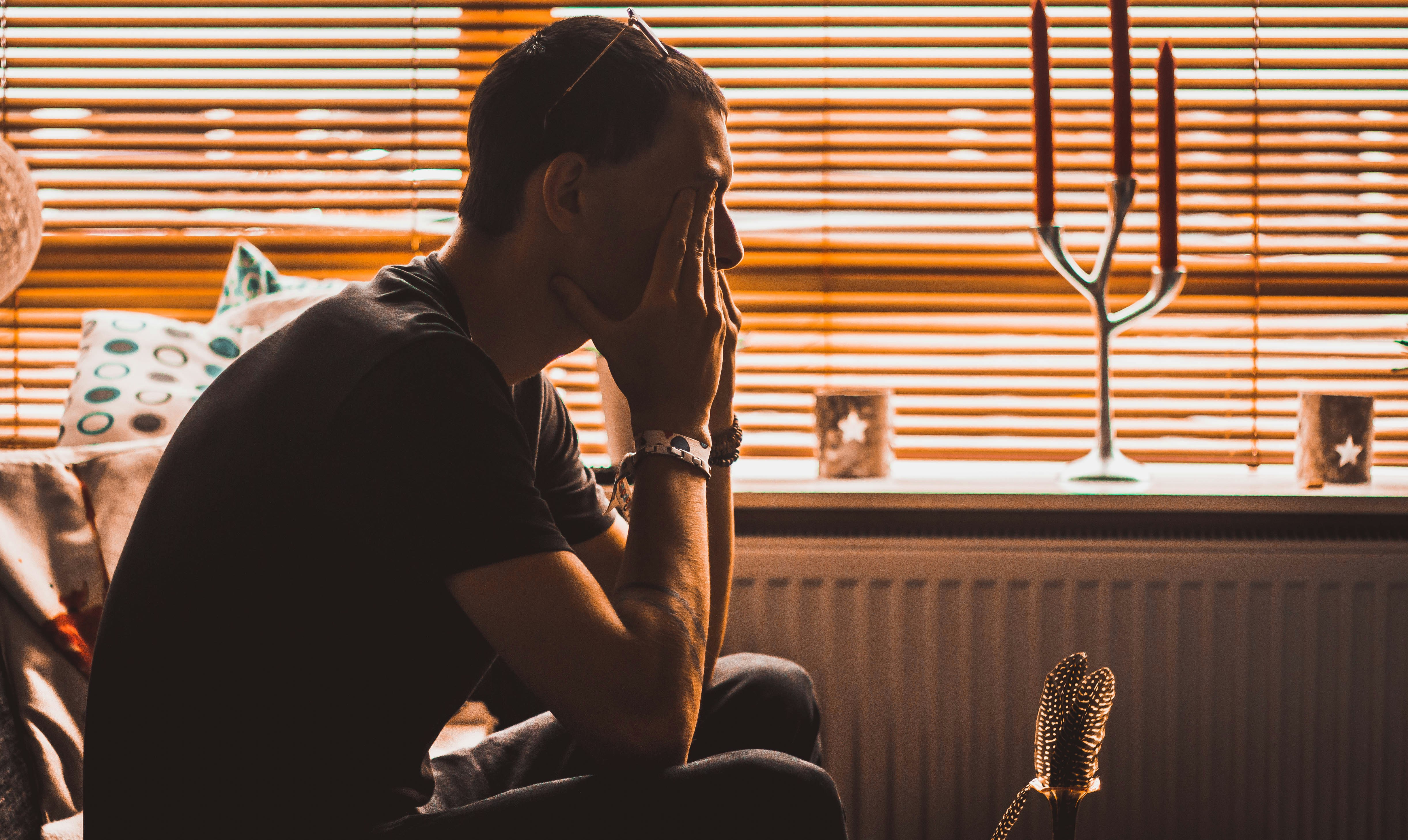 A man closed his eyes with hand in sitting position in sadness