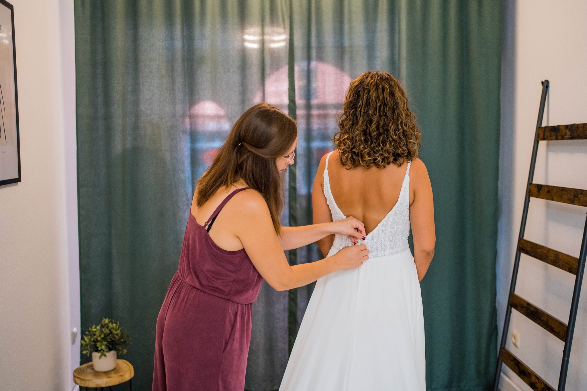Main Brautstübchen unterstützt eine Braut bei der Anprobe eines Spitzenhochzeitskleids – individueller Service für Bräute.