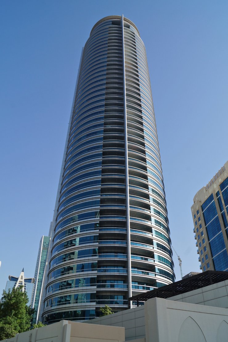 Modern architectural facade of a luxury residential skyscraper, offering exclusive real estate listings.