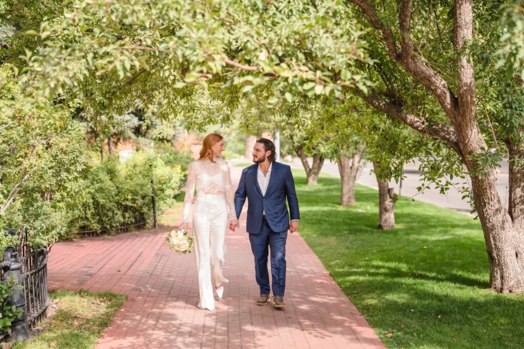Couple walking hand in hand along a garden path in Aspen