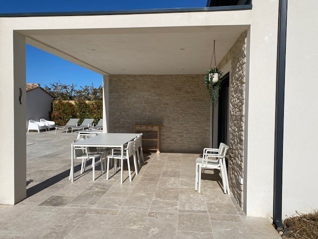Terrasse moderne abritée avec table et chaises blanches