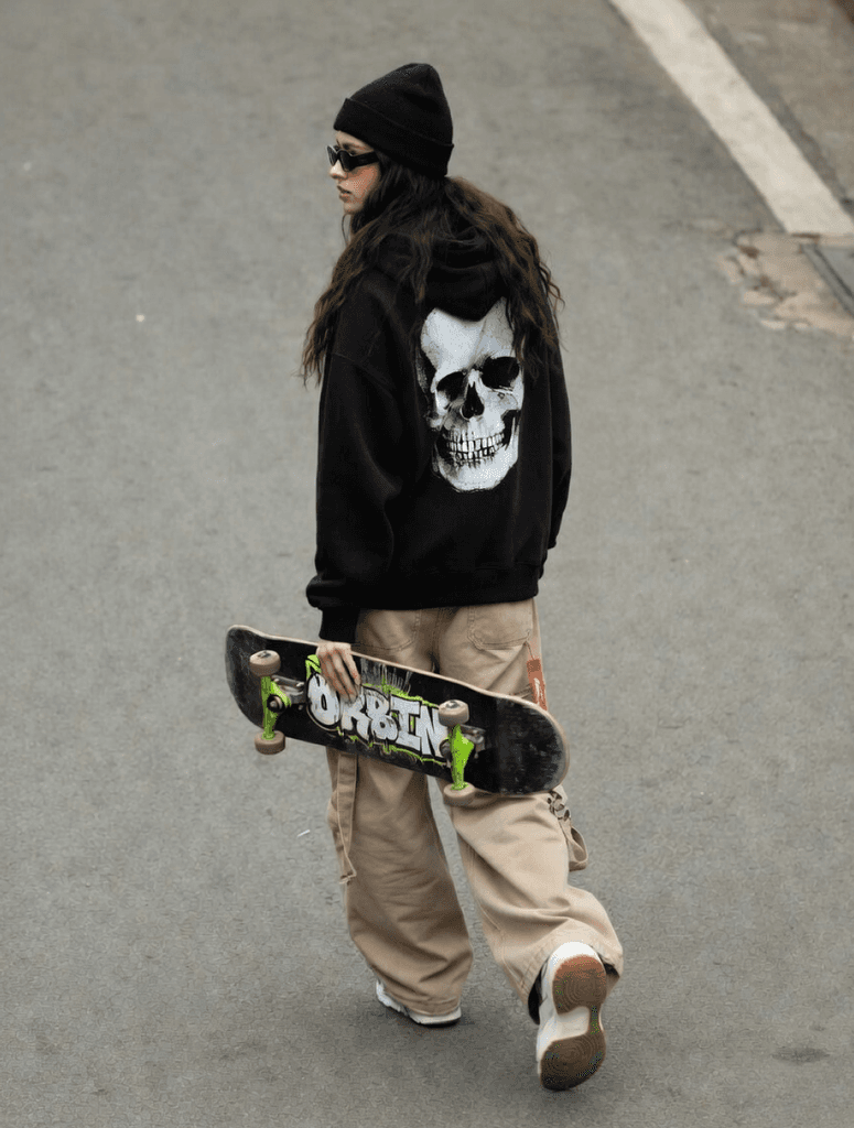Person walking away holding a skateboard on a street