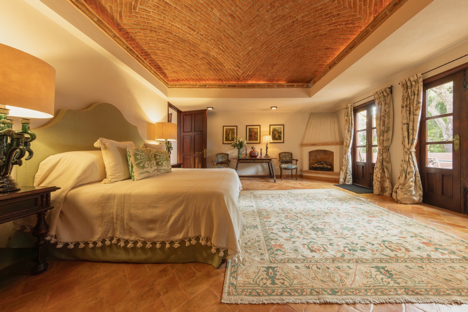 La Residencia guest bedroom with vaulted brick ceiling, wooden wardrobes, and Mexican artwork