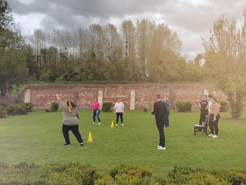 Des personnes en train de jouer à un jeu d'équipe en plein air lors d'un séminaire.