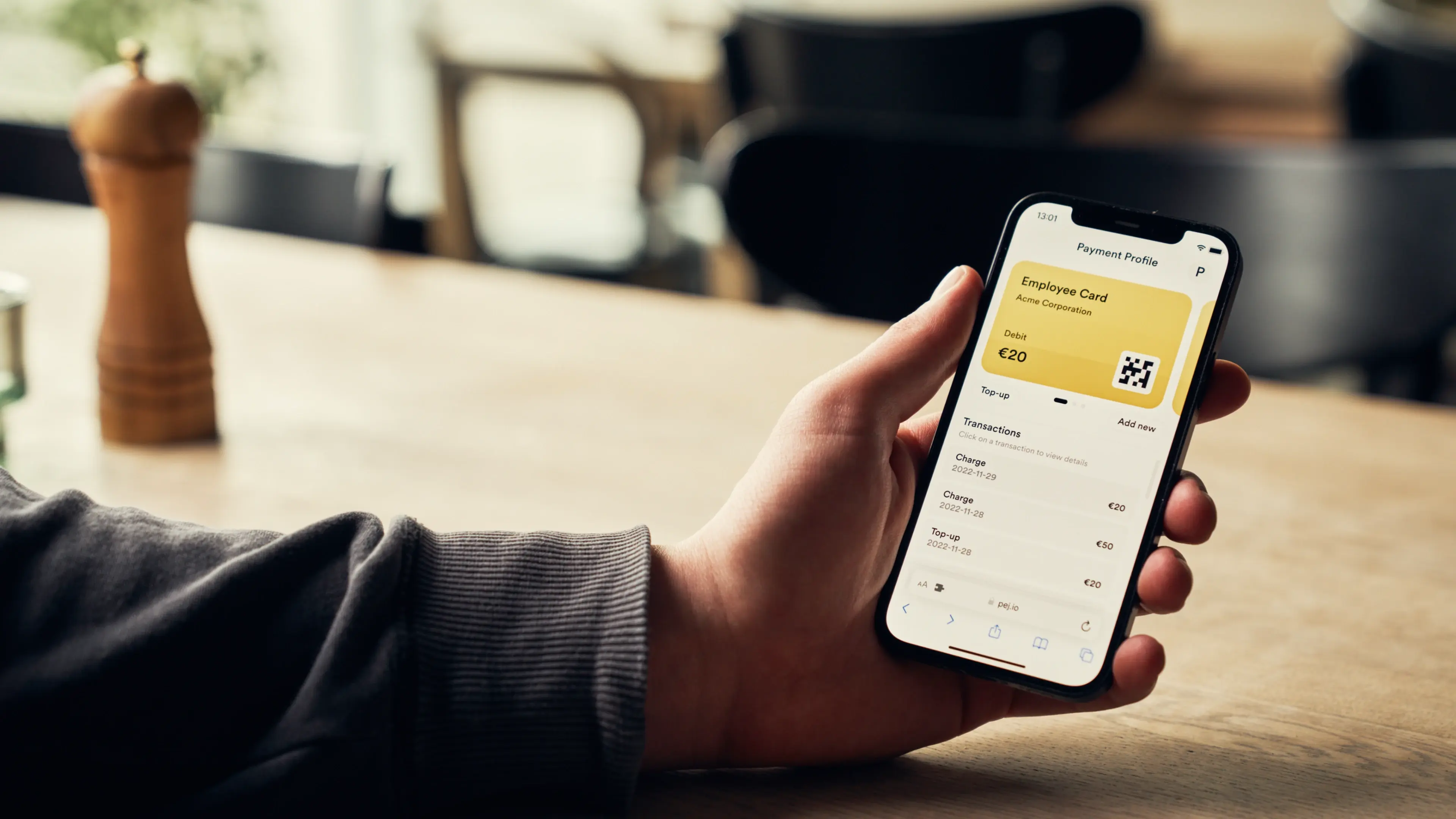 Hand holding a guest app to pay with credit, debit or salary deductions in the digital canteen