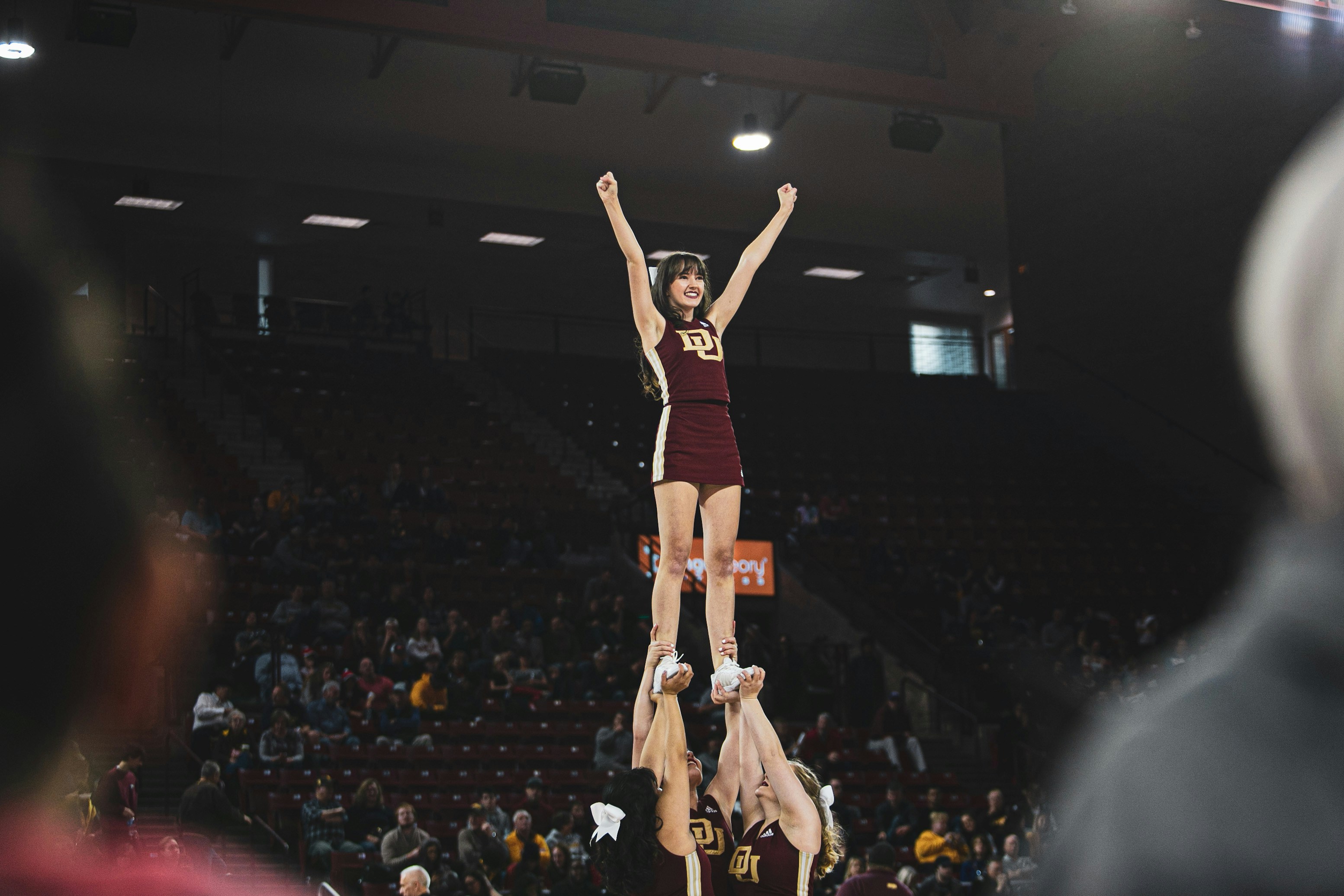 group of women doing cheer leading dance surrounded with people watching them