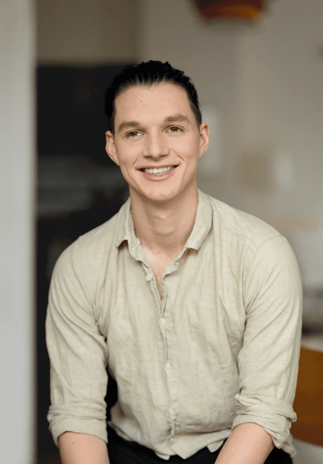 Smiling person seated indoors — founder of Seven Life Areas, offering guidance for living with clarity, harmony, and purpose.