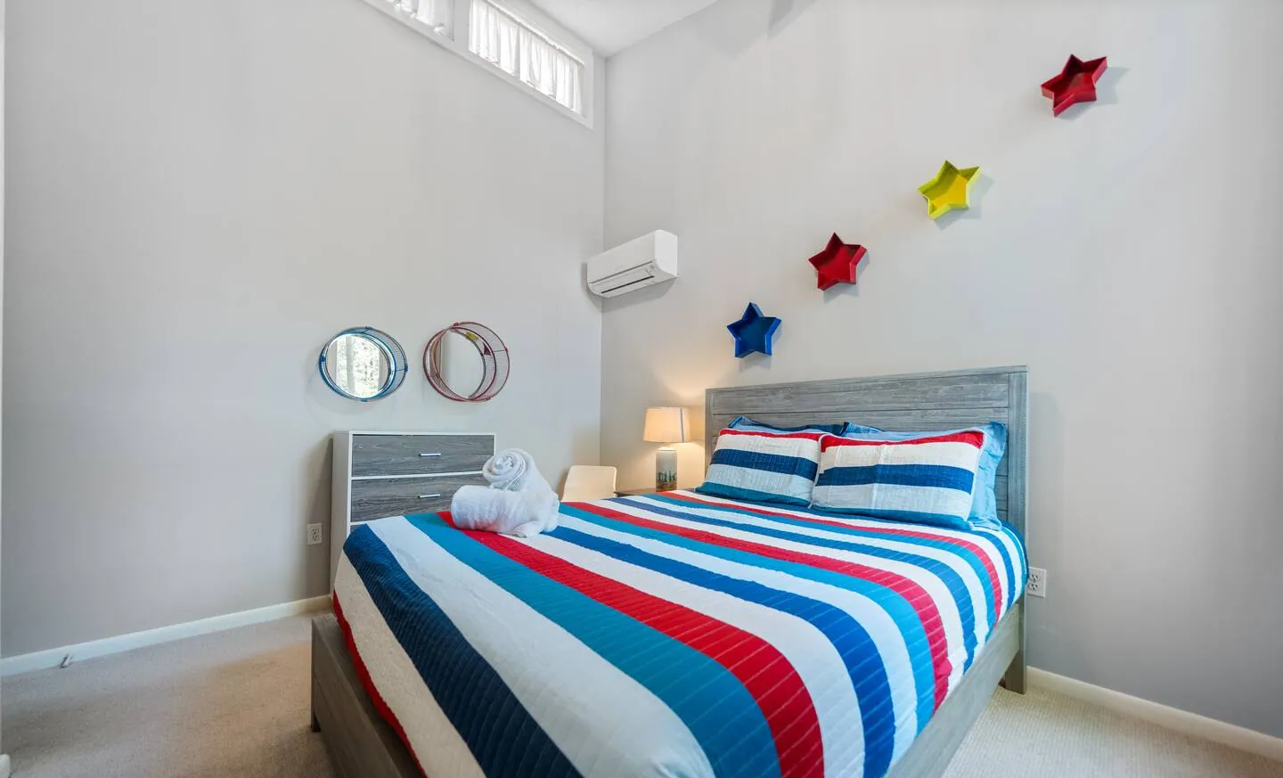 Queen bedroom with striped quilt and star wall decor at Lake Front, Lake Naomi