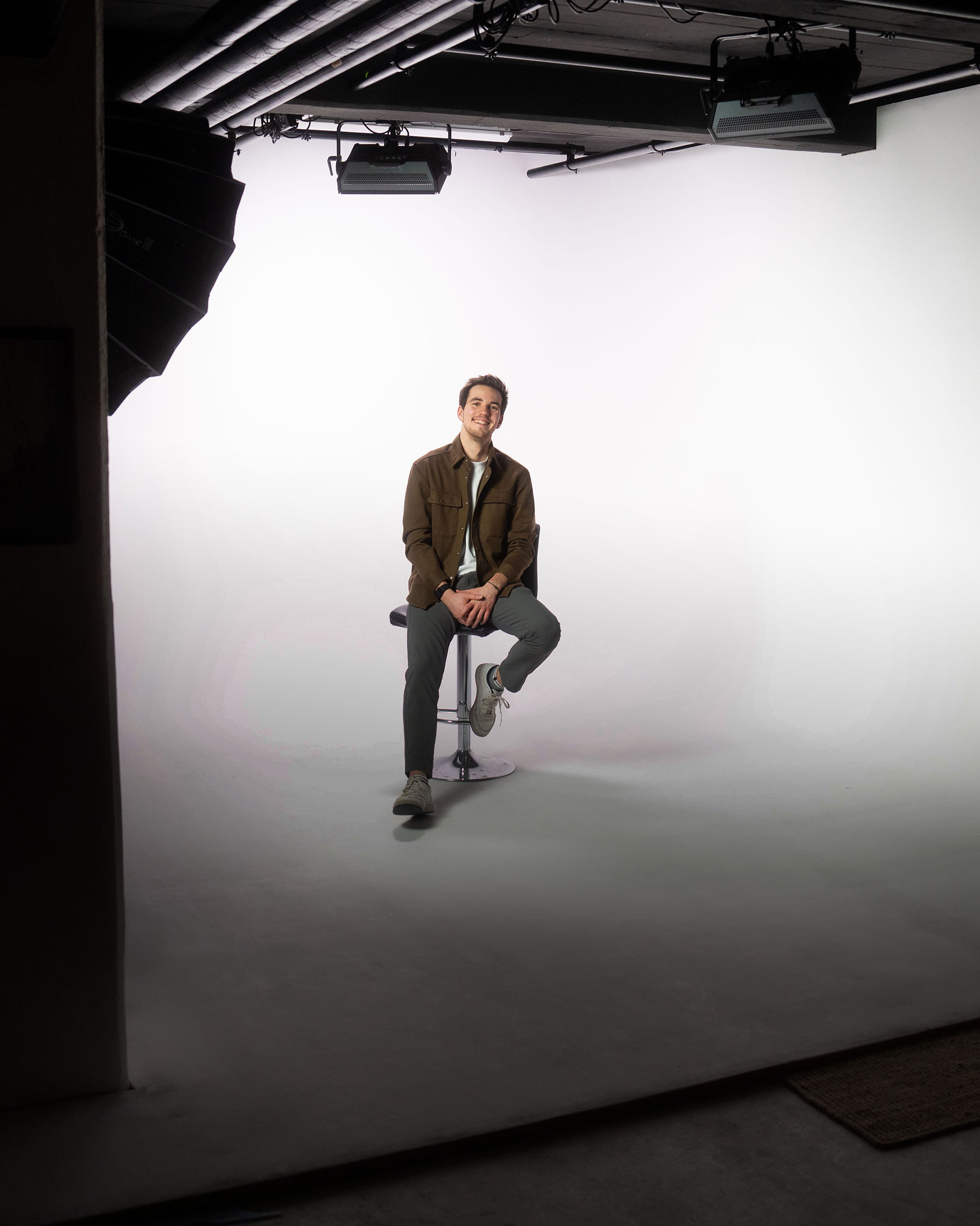 Person on stool in a film production studio, capturing campaign and ads.