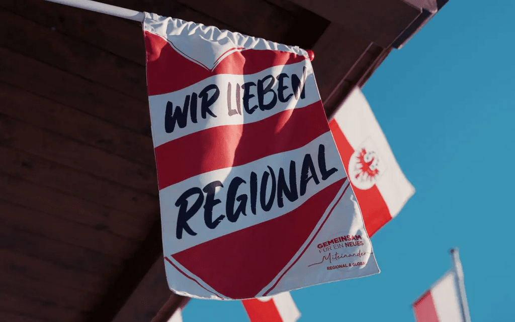 Ein Bild von einer Flagge in rot und weiß auf der steht „ WIR LIEBEN REGIONAL“.