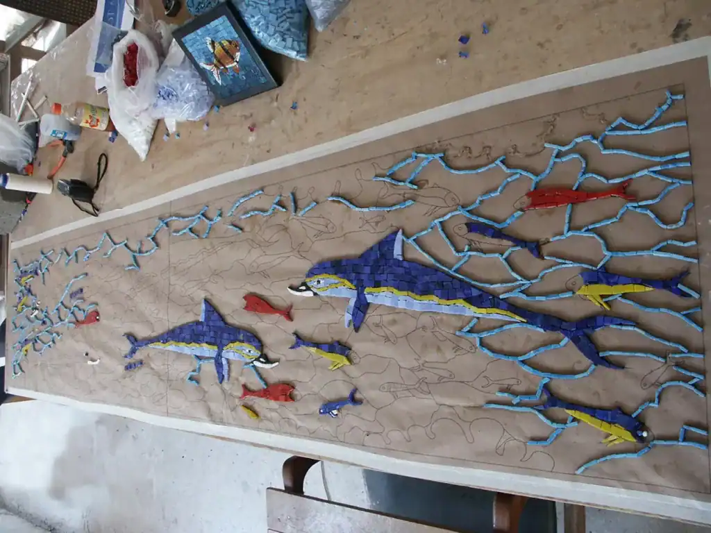 Fish mosaic art piece with vibrant blue, yellow, and red tiles.