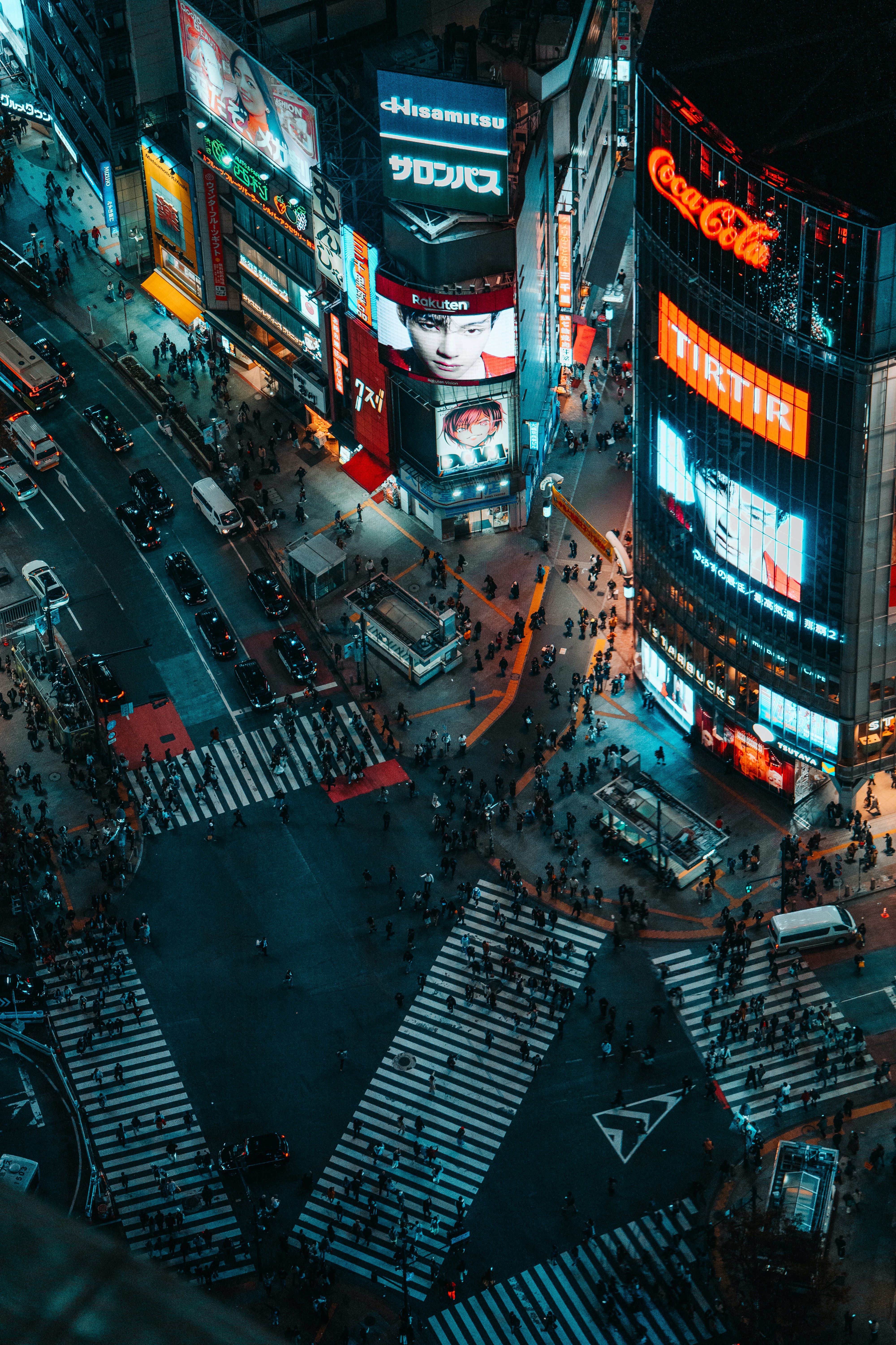 Busy city intersection at night with bright neon signs