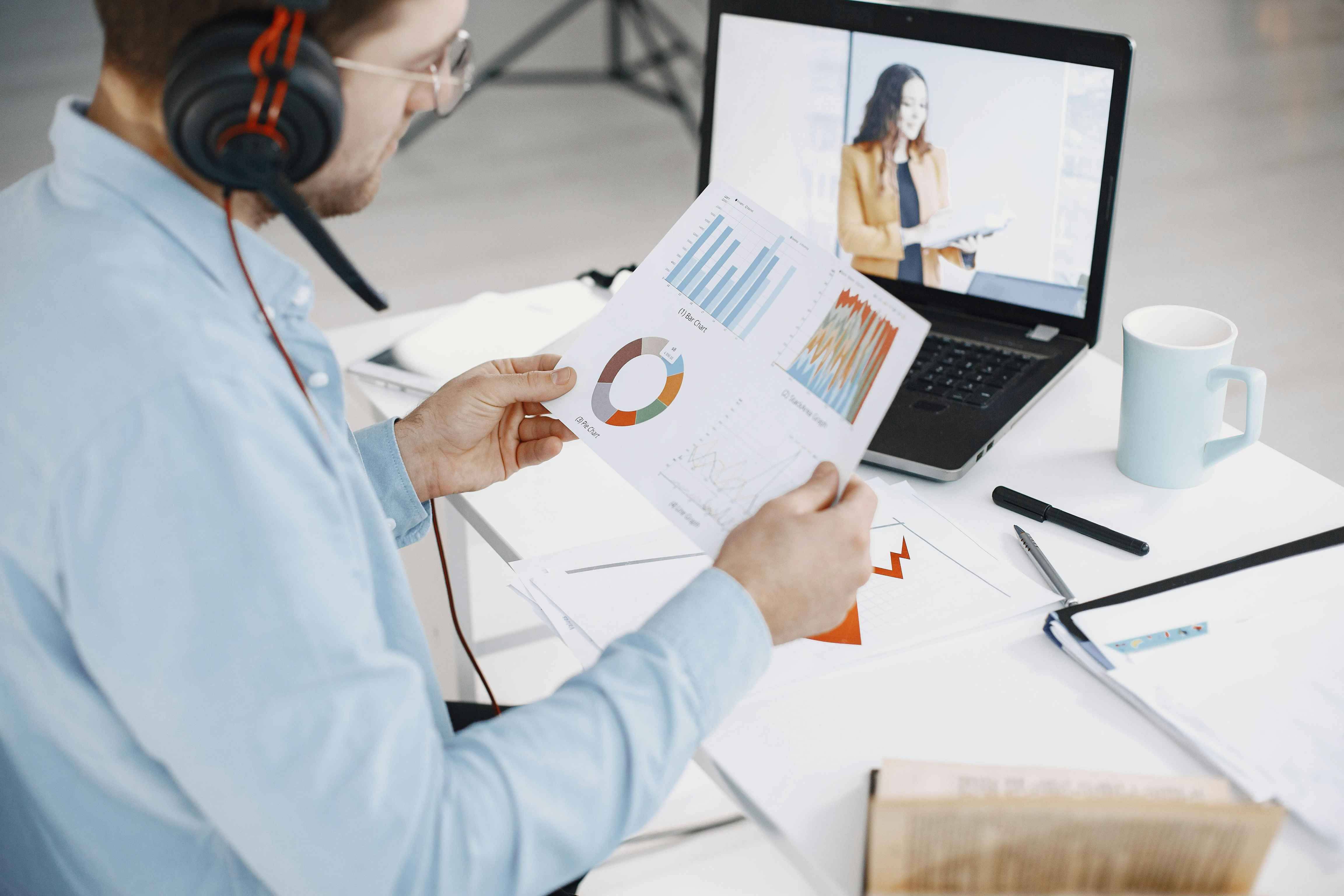 man-holding-video-analytics-with-video-playing-on-laptop