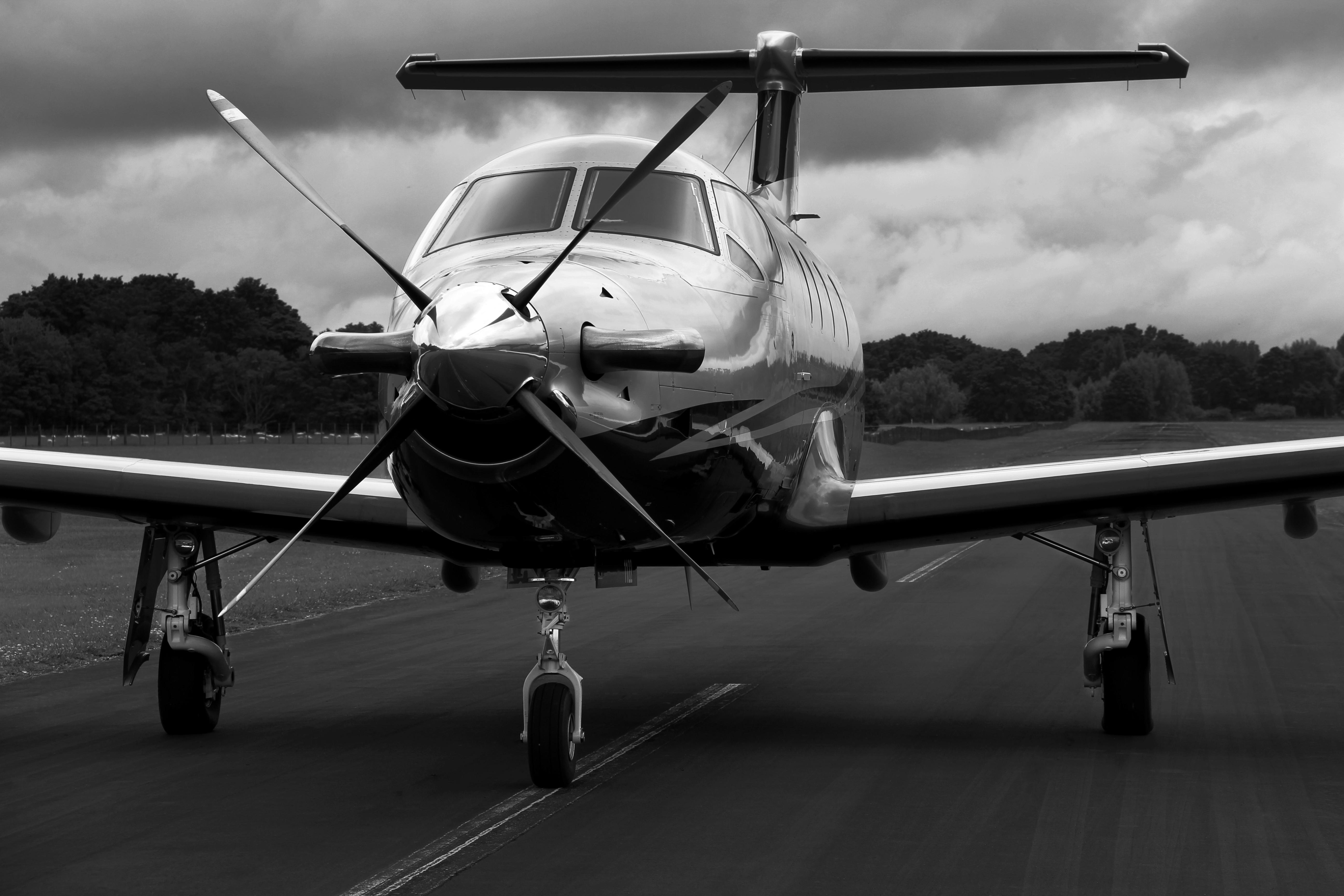 Private jet on an airport runway under a cloudy sky