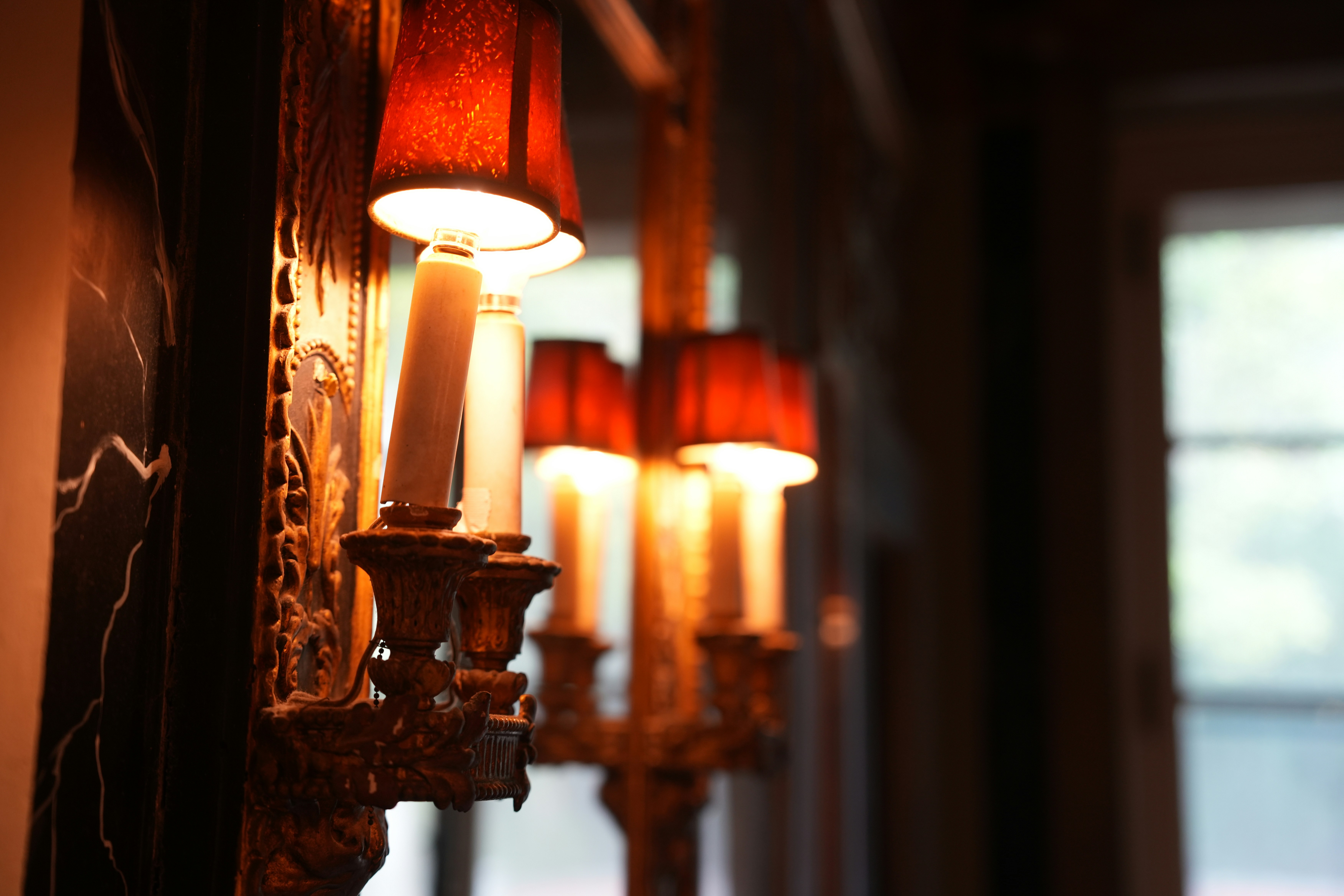 Close-up of candle-like wall lamps with warm illumination.