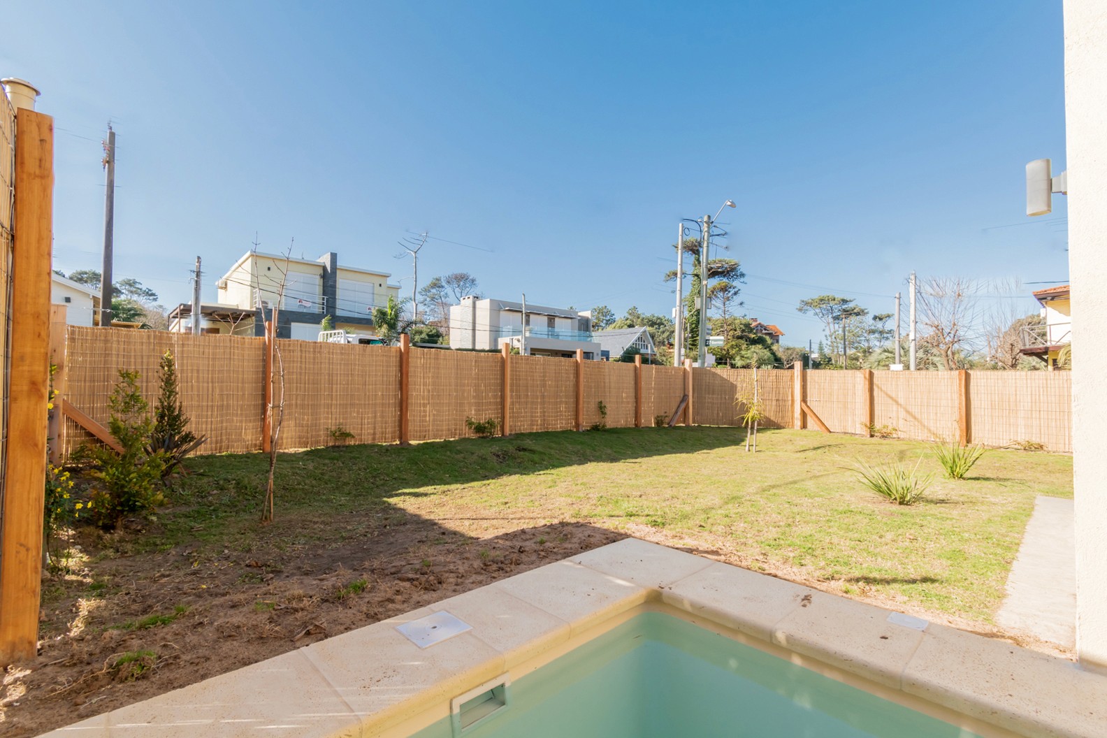 Jardín frontal de Casa Horneros con piscina climatizada - espacio exterior con jardín y piscina, ideal para relajarse al aire libre.