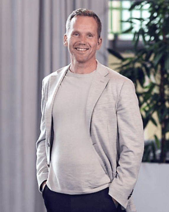 Profile portrait of a man in a white shirt against a light background