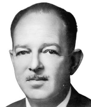 A black-and-white portrait of a man with a serious expression, neatly groomed mustache, and formal attire, conveying an aura of professionalism and mid-20th-century style. His steady gaze and composed demeanor suggest a person of authority or intellectual stature.