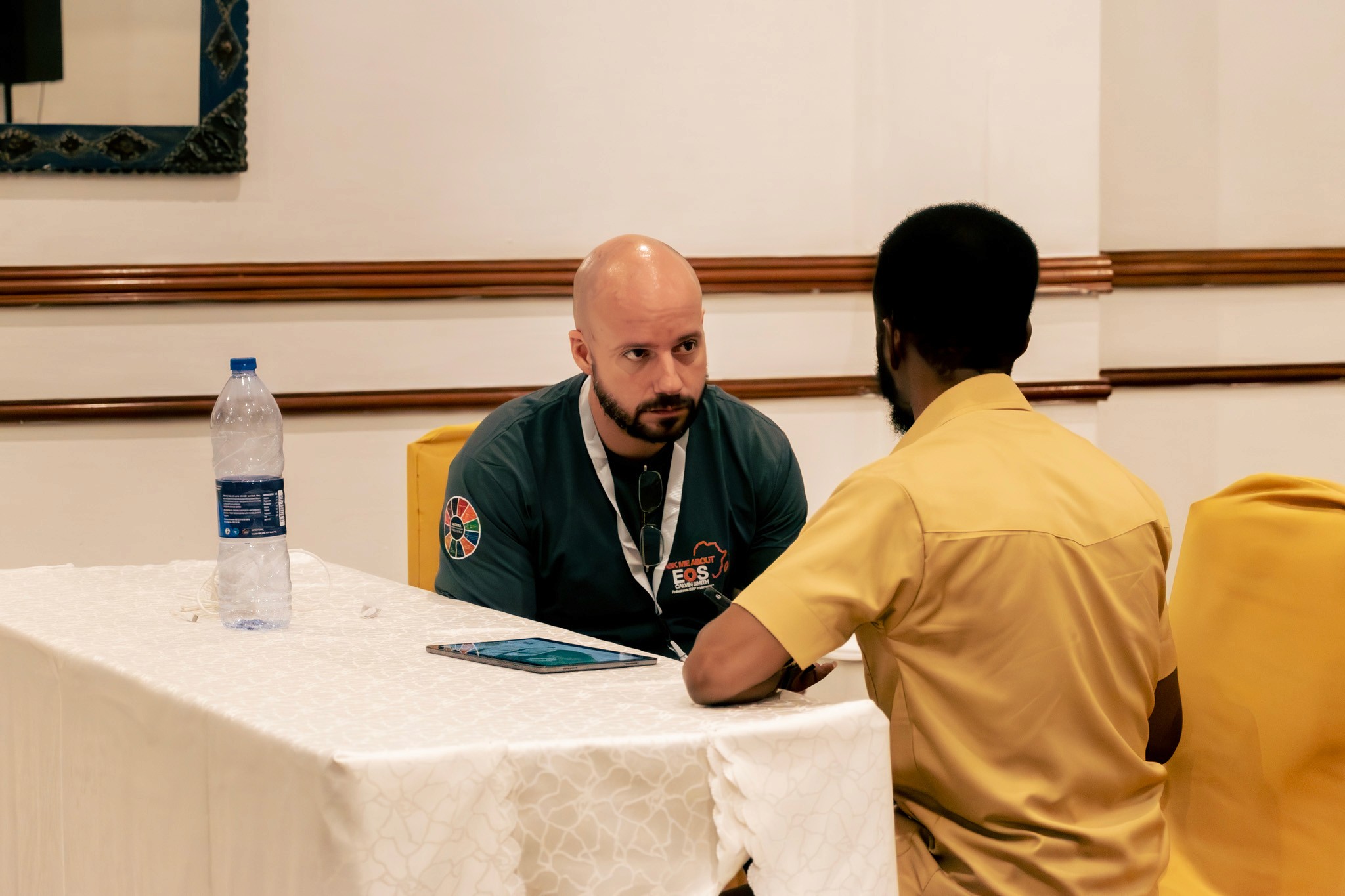 A wooden cube teeters on the edge of a rectangular block against a plain background.