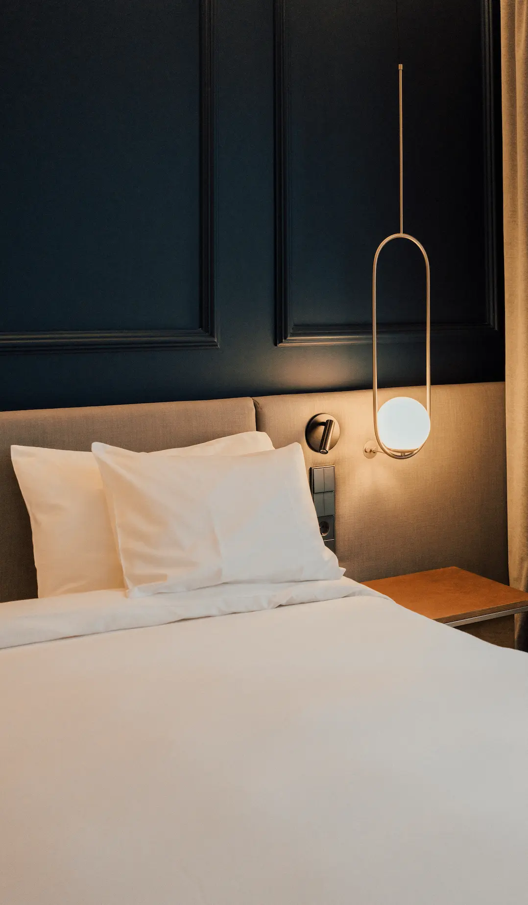 a bed with white sheets and pillows in a room