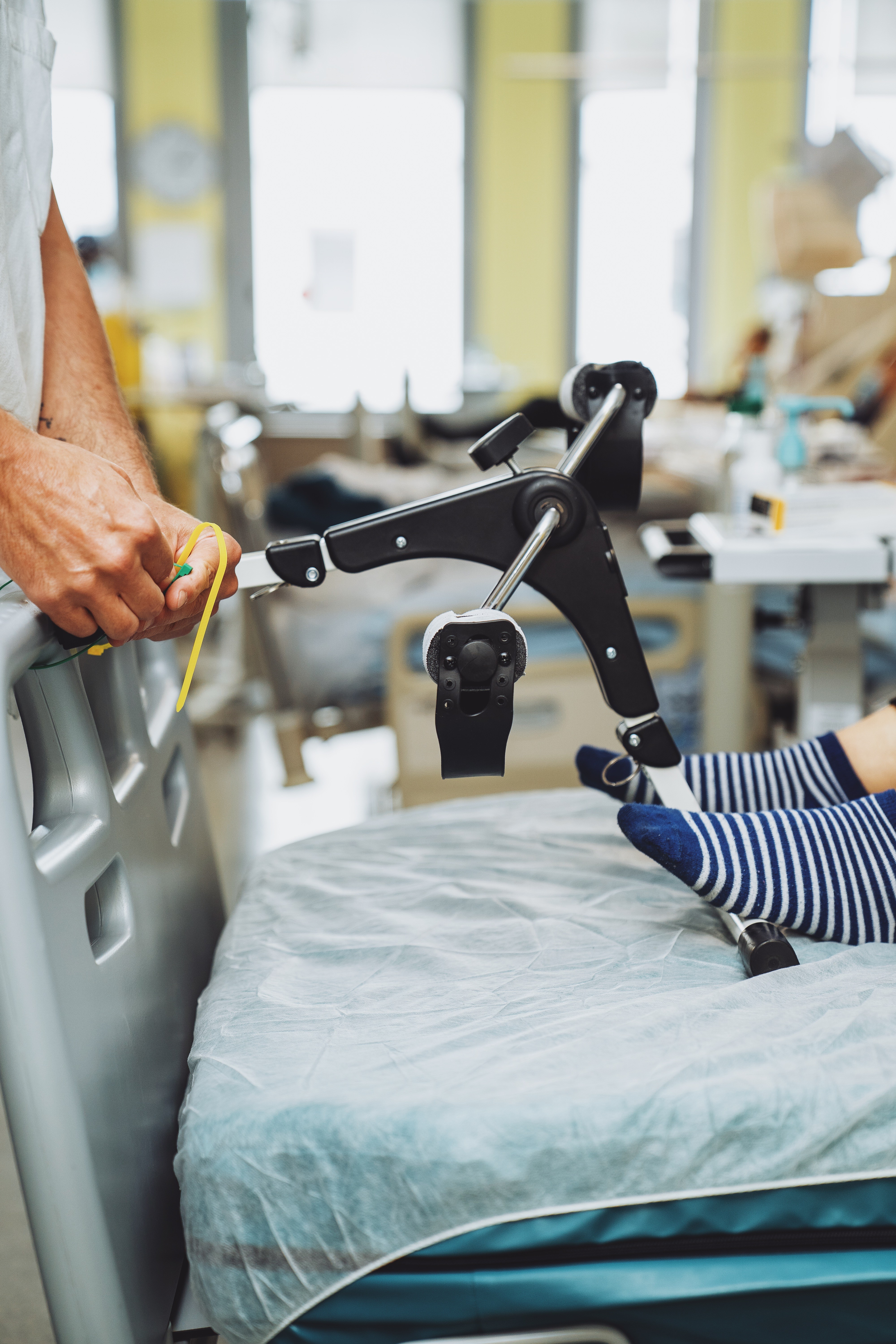Patient en rééducation effectuant un exercice de jambe avec appareil médical