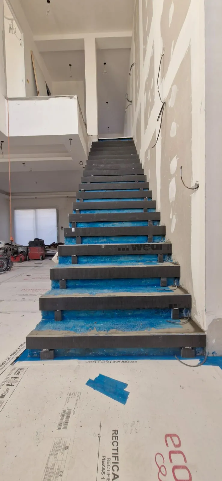Escalier avant habillage : structure nue protégée avant la pose des marches