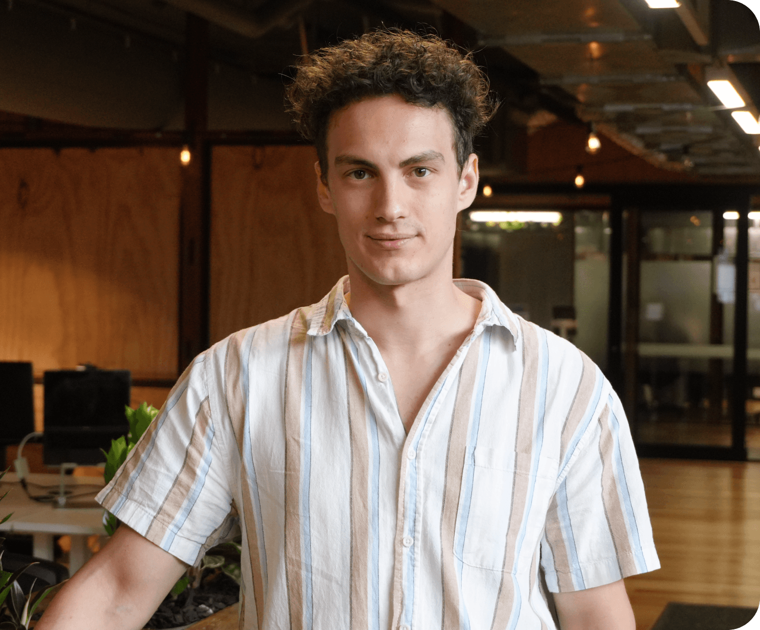 A portrait of a young man with a short sleeved linen shirt