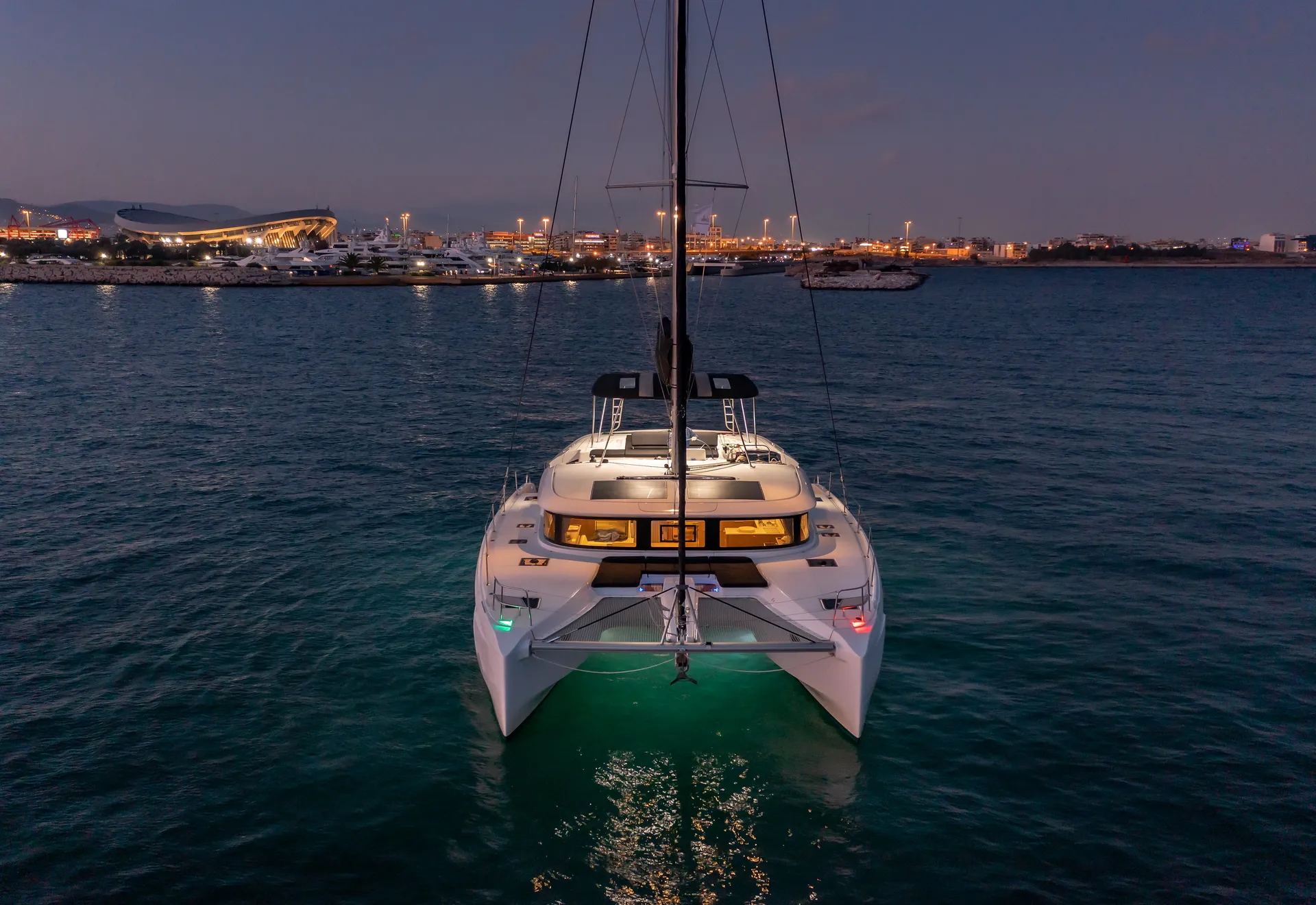White Rock 36 speedboat with captain at helm cruising calm blue waters near Paros coastline with hills in background.