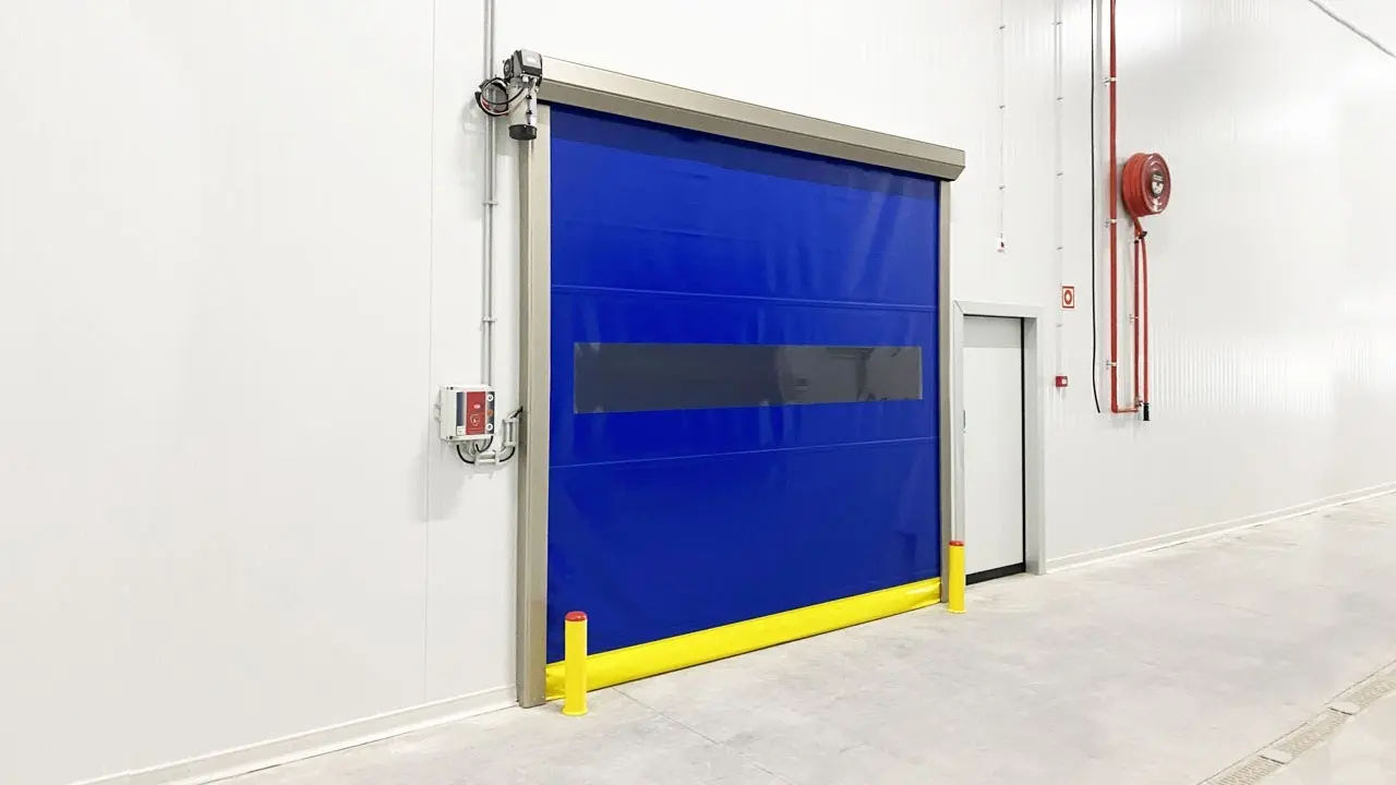 Puerta rápida de PVC color azul, con apertura mayor a 0.6 m/s. Ideal para áreas industriales que requieren aislamiento térmico, control de polvo, protección contra insectos, ruido y fuego.