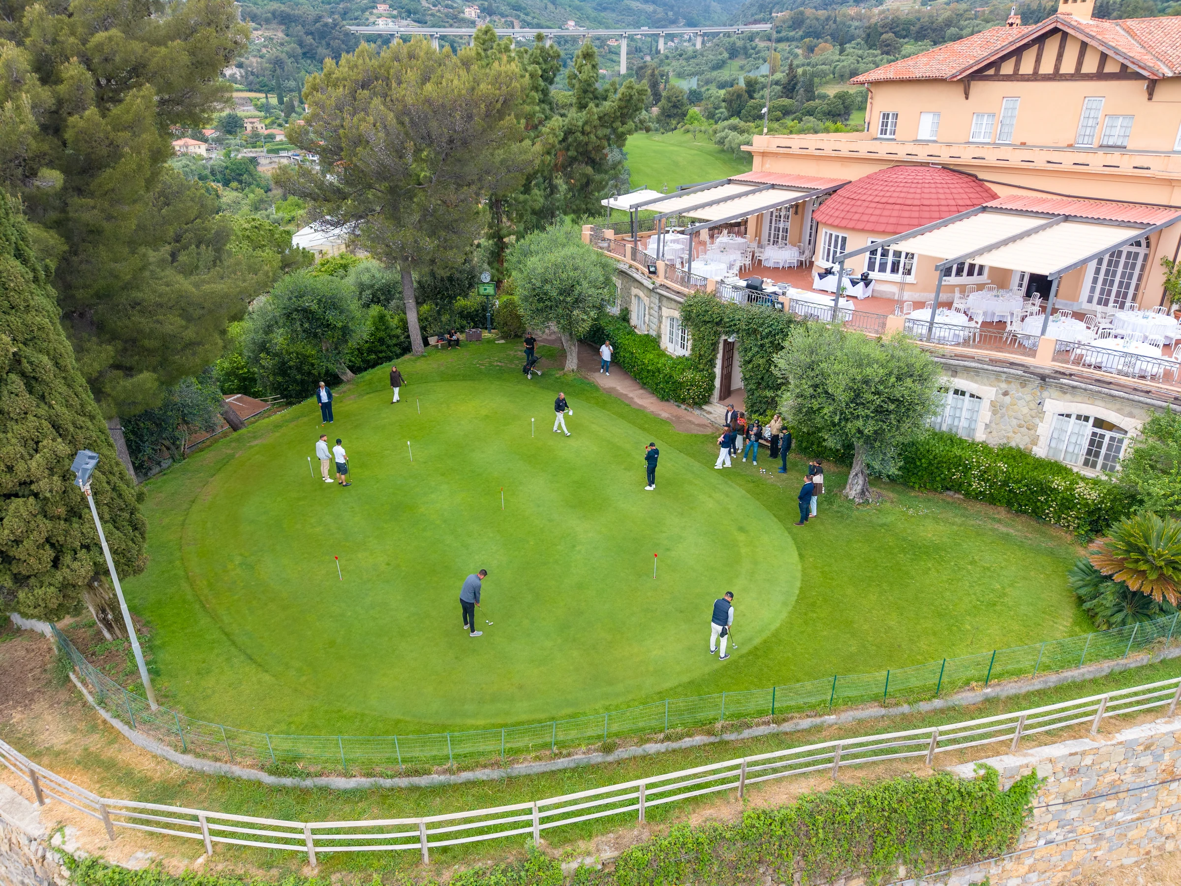 Aerial photograph of golfers and a terrace beside the course