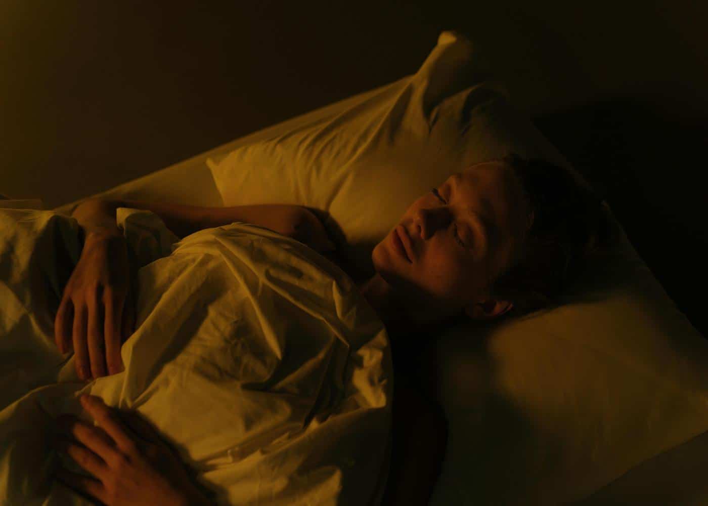 Neura Sleep Hygiene - Woman sleeping in a dark room