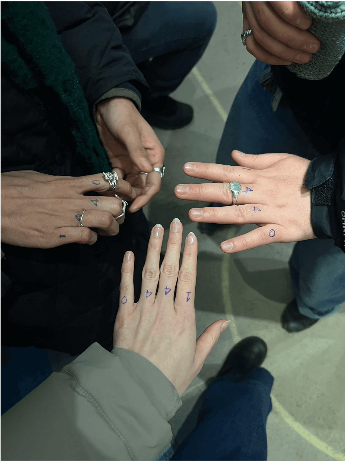 Groupe de mains rapprochées avec les chiffres “1 4 4 0” dessinés au stylo sur les doigts, symbole du Collectif1440.