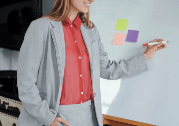 A woman lying down with a towel wrapped around her head, her face glistening with facial oil. Her eyes are closed, and she appears to be enjoying a spa treatment in a peaceful setting.