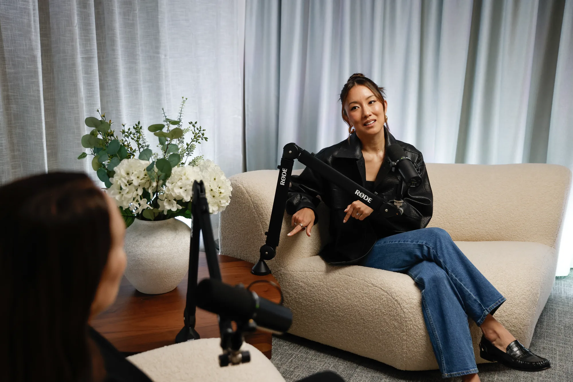 A guest seated on the bouclé sofa at the microphone in the RESIDENCE lounge